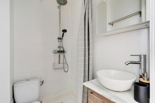 une salle de bain avec un lavabo, des toilettes et une douche dans l'établissement Au pied de l'arche de la défense, à Courbevoie