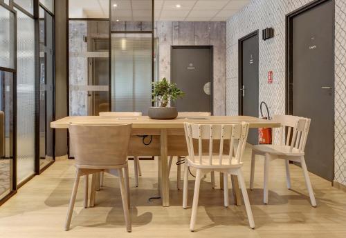 a dining room with a wooden table and chairs at B&B HOTEL Epernay in Épernay