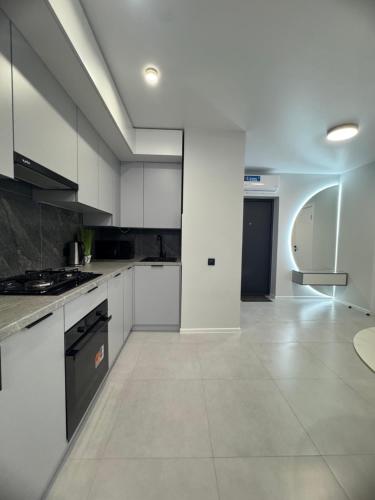 a large kitchen with white cabinets and a tile floor at Новобудова вулиця Стрийська 45а FABRIK in Lviv