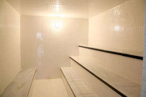 y baño con ducha y paredes de azulejos blancos. en Ancoradouro Hotel - Centro De Porto Seguro en Porto Seguro