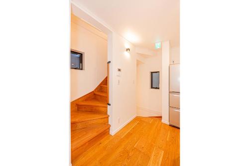 an empty room with a refrigerator and a hallway at Arashi hotel 嵐ホテル in Tokyo