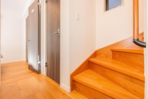 a hallway with wooden stairs in a house at Arashi hotel 嵐ホテル in Tokyo