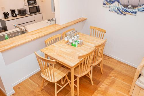 a dining room with a wooden table and chairs at Arashi hotel 嵐ホテル in Tokyo