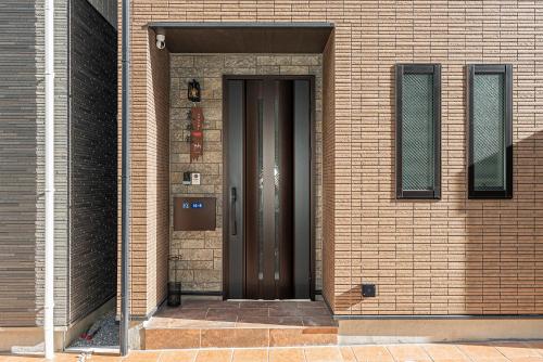 a brown door on the side of a brick building at Arashi hotel 嵐ホテル in Tokyo