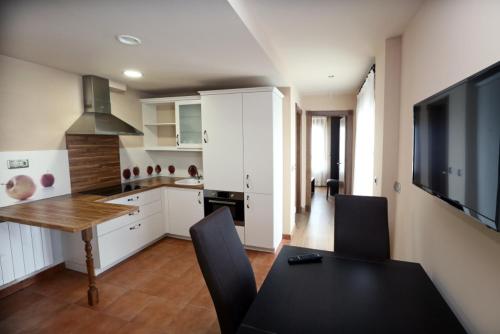 kuchnia ze stołem jadalnym i telewizorem w obiekcie Apartamentos Villa Sofía w mieście San Vicente de la Barquera