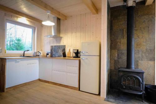 a kitchen with a refrigerator and a stove at COZYWOOD Domki wypoczynkowe z balią i sauną na Kaszubach in Pomlewo