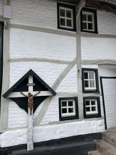 a cross on the side of a building with windows at Authentieke 4 persoons cottage vlakbij Valkenburg in Voerendaal