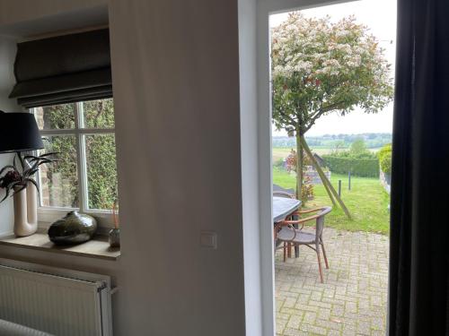 a door leading to a patio with a table and a window at Authentieke 4 persoons cottage vlakbij Valkenburg in Voerendaal