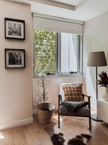 a living room with a chair and a window at Collins Escape - 2 bedrooms with Collins St Balcony in Melbourne