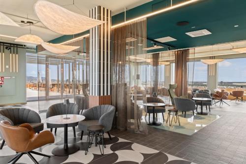 a restaurant with tables and chairs and windows at HANS-Y Apartments inklusive Outdoorpool & Bar in Vienna