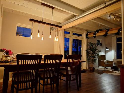 a dining room with a table and chairs at Uniek vakantiehuis - nabij molen, meer, strand & stad' in Hoorn