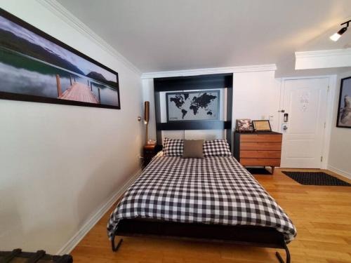 a bedroom with a bed with a checkered blanket at Studio Rustico Chic Nearby Piedmonts Hotspots in Piedmont