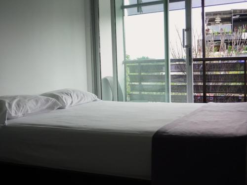 a bed in a room with a large window at Depeapan in Cali