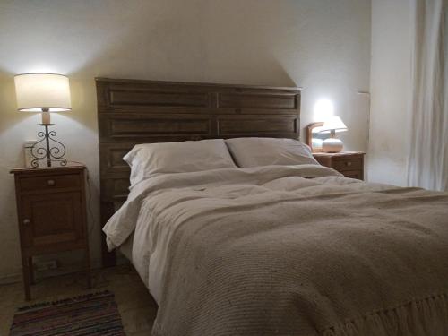 a bedroom with a large bed with two night stands at Mirador del Talita in Alpa Corral