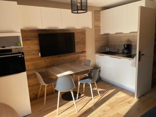 une cuisine avec une table et des chaises dans une cuisine dans l'établissement Charmant Studio proche du centre de Châtel, à Châtel