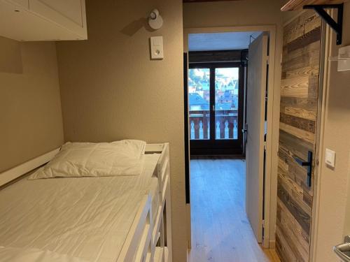 - une chambre avec un lit et une porte donnant sur un balcon dans l'établissement Charmant Studio proche du centre de Châtel, à Châtel