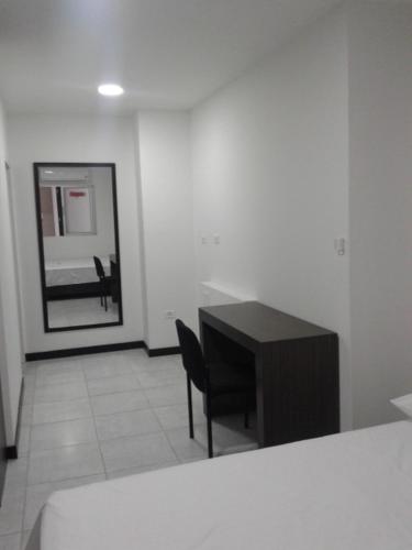 a room with a black desk and a mirror at Depeapan in Cali