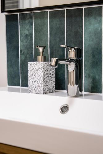 La salle de bains est pourvue d'un lavabo et d'un robinet. dans l'établissement Cosy Haven Studio rénové, élégant Pougues les Eaux, à Pougues-les-Eaux