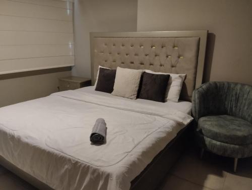 a bedroom with a bed with a clock and a chair at Departamento en puerto santana in Guayaquil