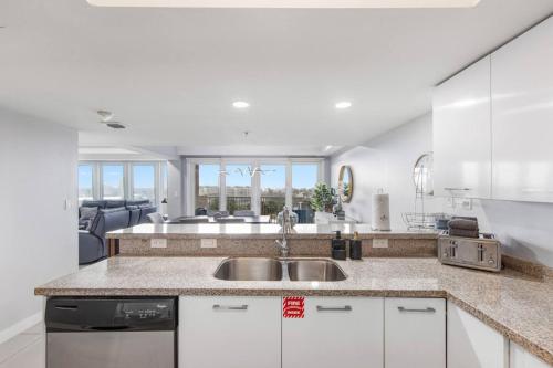 a kitchen with white cabinets and a sink at Solare Tower Sunset Panorama Paradise in South Padre Island