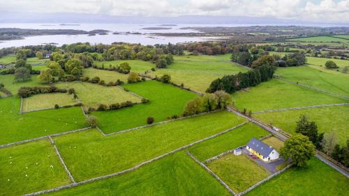 an aerial view of a field with a house on it at Lough Mask Fishing Lodge in Ballinrobe