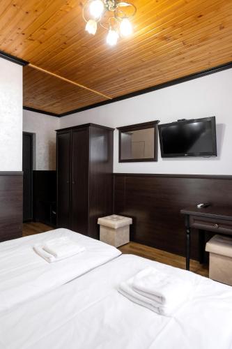 a bedroom with two beds and a flat screen tv at Готельний комплекс Парламент, Яблуниця in Yablunytsya