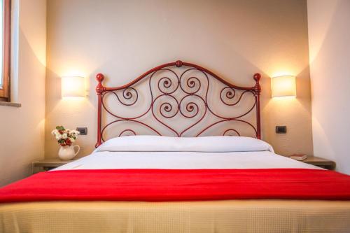 a bedroom with a large bed with a red blanket at La Locanda Della Chiocciola in Orte