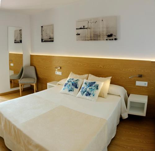 1 dormitorio con 1 cama blanca y 2 almohadas en Hotel Rosa Nàutica en Malgrat de Mar