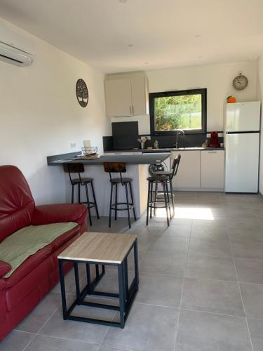un salon avec un canapé rouge et une cuisine dans l'établissement Villa des Chênes, à Figari