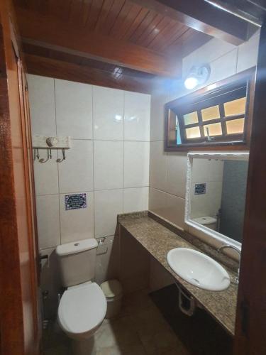 a small bathroom with a toilet and a sink at Suítes Quintal de Lázaro 3 in Ubatuba