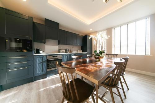 a kitchen with a wooden table and some chairs at The Old Bank Apartments in Blackpool