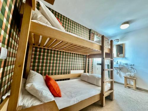 ein Schlafzimmer mit zwei Etagenbetten in einem Zimmer in der Unterkunft MCX Vacation Rental - Maison Cian, Appartamento con balconi panoramici nel cuore di Breuil Cervinia in Breuil-Cervinia