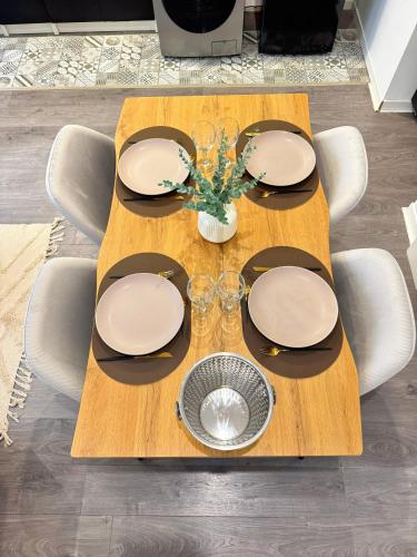 a wooden table with plates and glasses on it at Narbonne centre New york in Narbonne