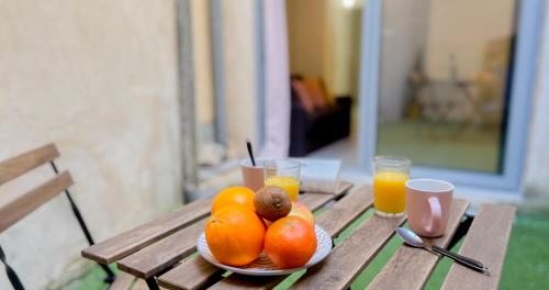 une plaque d'oranges sur une table avec des verres de jus d'orange dans l'établissement Hypercenter - Private Patio - Le nid du Palais !, à Avignon