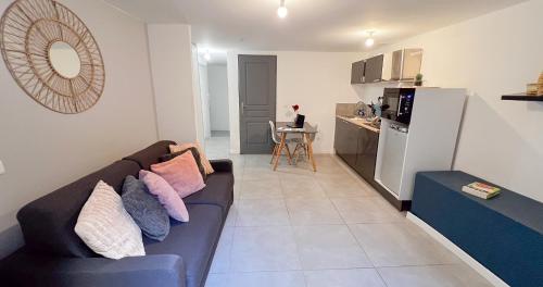 un salon avec un canapé et une cuisine dans l'établissement Hypercenter - Private Patio - Le nid du Palais !, à Avignon