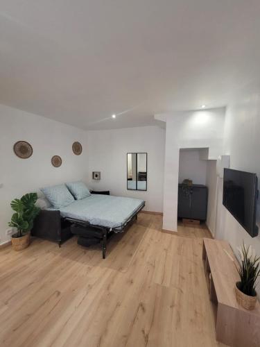 une chambre avec un lit et une télévision à écran plat dans l'établissement Venise Provençal, à Martigues