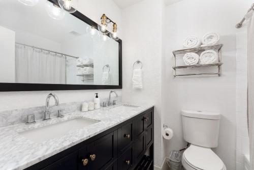 a bathroom with a sink and a toilet and a mirror at Spacious and Cozy 5 Bed 3 Bath Vacation House W 2 King 3 Queen! Sleep 12! 15Min to Red Rocks in Arvada