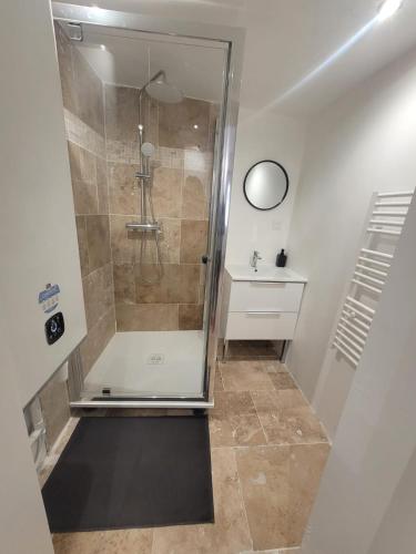 une douche avec une porte vitrée dans une salle de bain dans l'établissement Venise Provençal, à Martigues