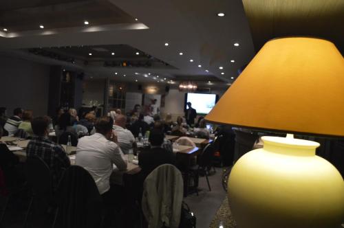 a group of people sitting at tables in a restaurant at Hotel The New Fox in Affligem