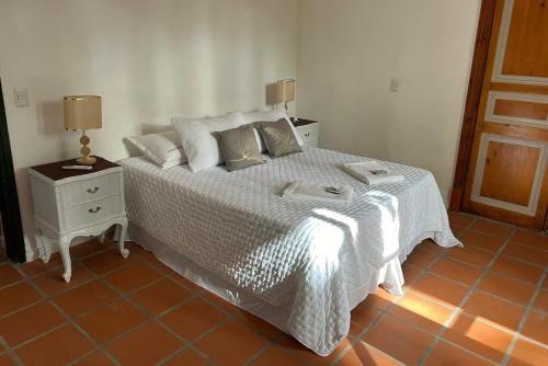 a bedroom with a bed with a white comforter at Casa de la Flor by Posada de la Flor in Colonia del Sacramento