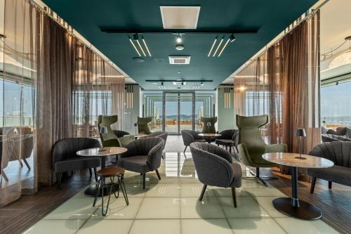 a restaurant with tables and chairs and windows at HANS-Y Apartments inklusive Outdoorpool & Bar in Vienna