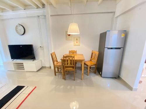 una cocina y comedor con una mesa y un refrigerador en Townhouse nearby Klong Dao beach with loft, en Ban Mo Nae