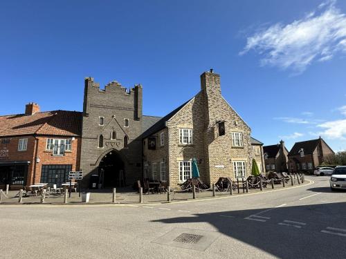 a large stone building with tables in front of a street at The Filey House in Filey