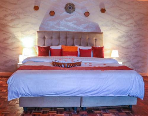ein Schlafzimmer mit einem großen Bett mit roten Kissen in der Unterkunft C & G house in Nairobi
