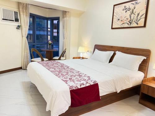 a bedroom with a large bed and a window at Grand Riviera Suites in Manila