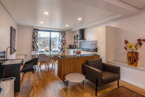 a kitchen and living room with a table and chairs at Your Azorean Home RRAL 3378 in Ribeira Grande