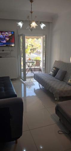 a living room with a couch and a tv at Sea , Airport,Parking 56sqm Apt in Thessaloniki
