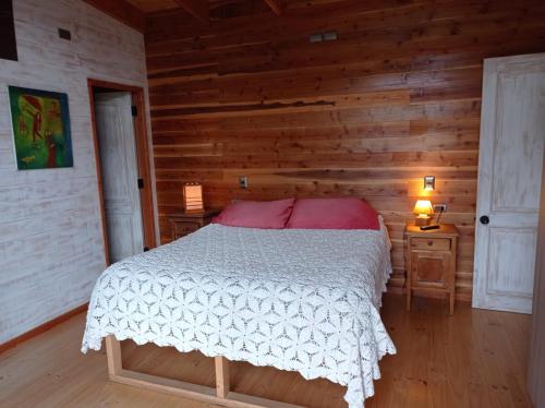 a bedroom with a bed in a log cabin at Casa con hermosa vista y tranquilidad in Pucón