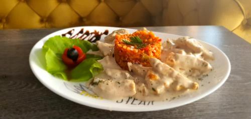 a plate of food with chicken and rice on a table at Hotel S in Berane