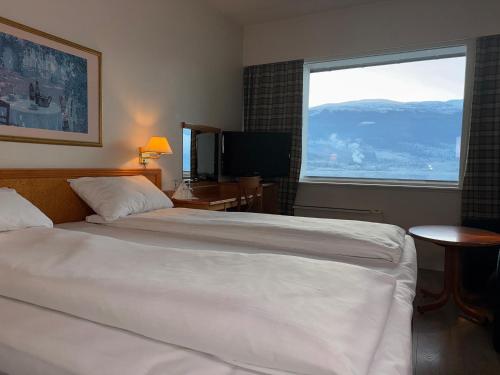 a hotel room with a large bed and a large window at Park Hotel Vossevangen in Vossevangen